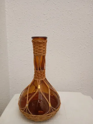 Garrafa antigua de cristal ámbar y mimbre