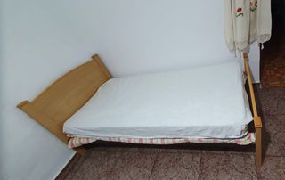 Cama de madera con cabecero curvo