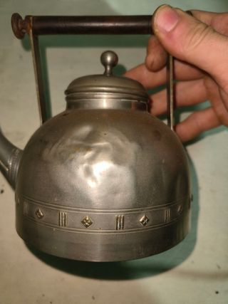 Tetera antigua de metal con asa de madera