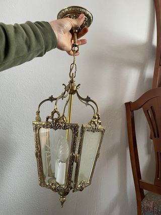 Dos lámparas de techo doradas con farolillos.