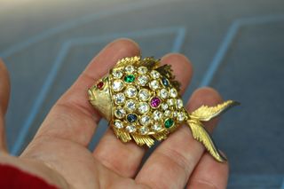 Conjunto de broche y pendientes en metal dorado y cristales.