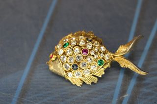 Conjunto de broche y pendientes en metal dorado y cristales.