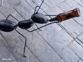 Escultura de hormiga forjada con botella