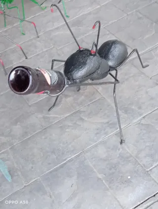 Escultura de hormiga forjada con botella