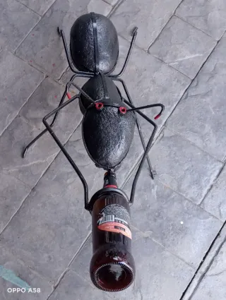 Escultura de hormiga forjada con botella