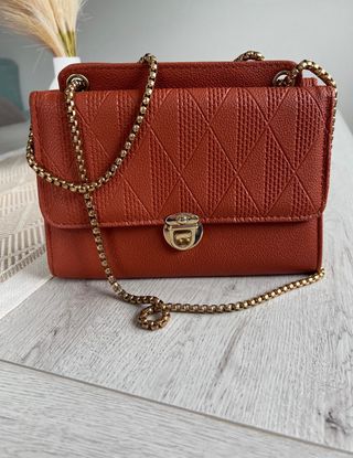 Bolso naranja con cadena dorada