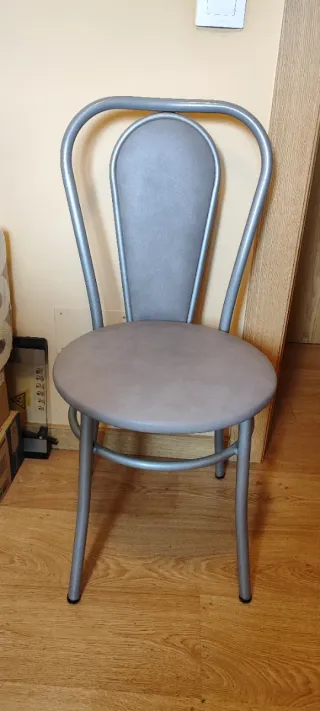 Sillas de cocina plateadas y mesa redonda blanca