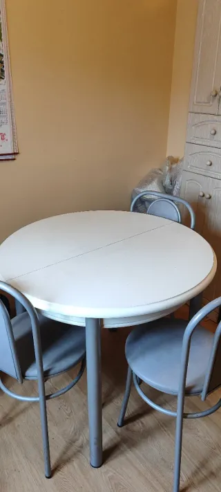Sillas de cocina plateadas y mesa redonda blanca