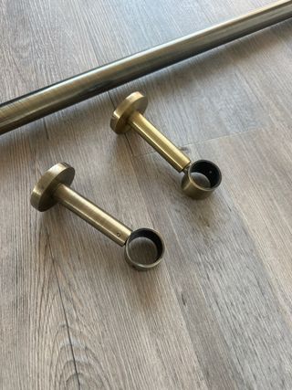 Barra de cortina dorada con soportes