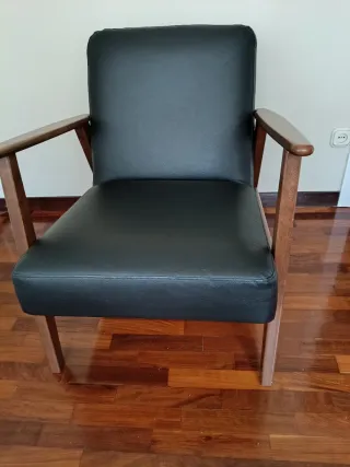 Sillón de piel negro con estructura de madera