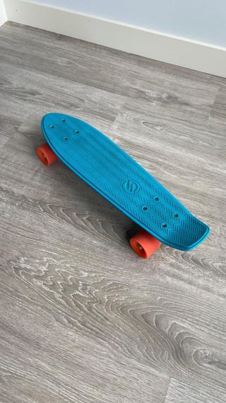 Monopatín azul 55cm con ruedas naranjas