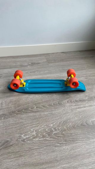 Monopatín azul 55cm con ruedas naranjas