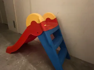 Tobogán infantil rojo, azul y amarillo