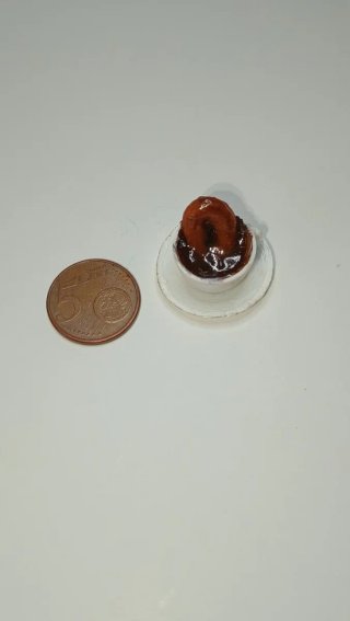 Tazza di cioccolato con ciambella in miniatura