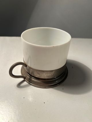 Taza antigua con soporte metálico