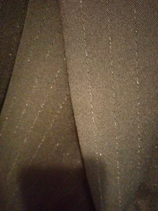 Traje de pantalón negro y finas rallas brillo.