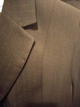 Traje de pantalón negro y finas rallas brillo.