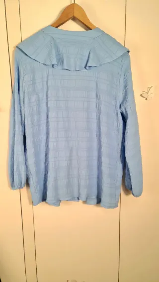 Blusa azzurra con volant