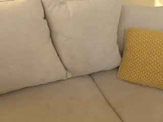 Sofá de tela beige.