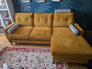 Sofá cama de terciopelo mostaza.