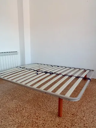 Cama con somier metálico y láminas de madera