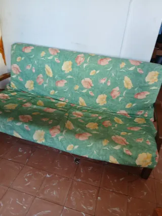 Sofá verde con flores rosas y amarillas