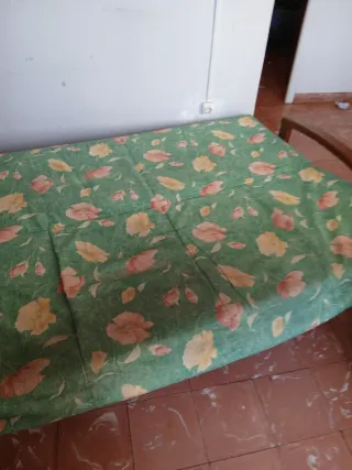 Sofá verde con flores rosas y amarillas