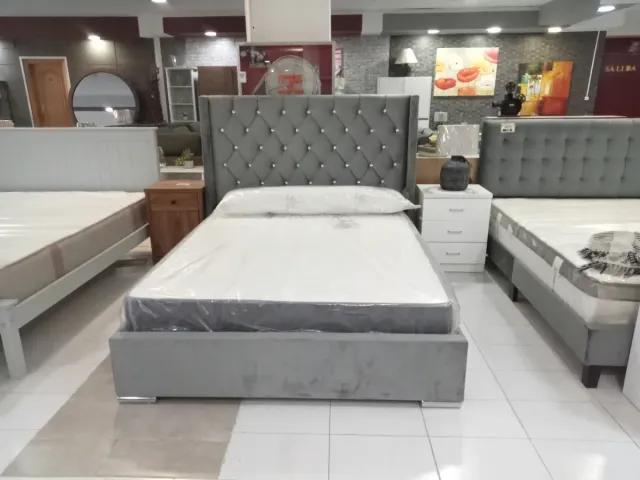 Cama tapizada gris con cabecero de perlas