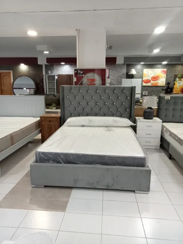 Cama tapizada gris con cabecero de perlas