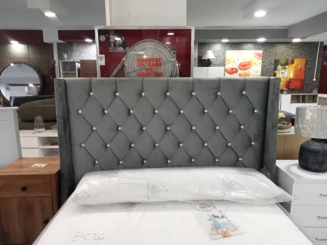 Cama tapizada gris con cabecero de perlas