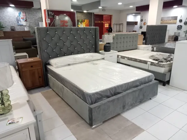 Cama tapizada gris con cabecero de perlas
