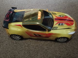 Coche de juguete dorado con luces y movimiento