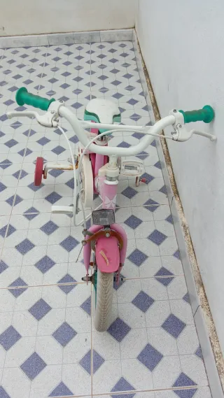 Bicicleta infantil rosa con ruedas de apoyo