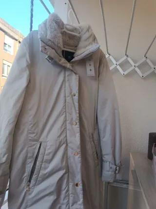 Plumífero gris claro con cuello de pelo