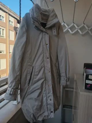 Plumífero gris claro con cuello de pelo