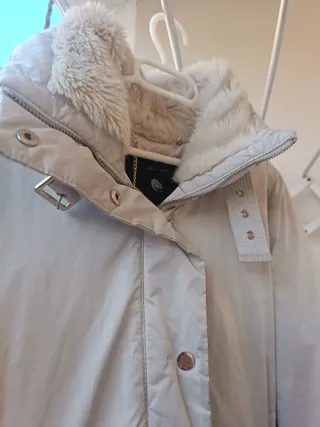 Plumífero gris claro con cuello de pelo