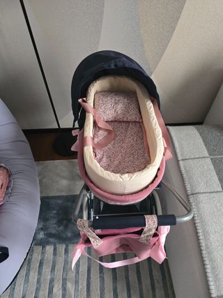 Coche de muñecas rosa con capota