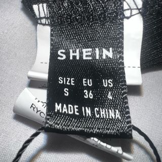 Top asimétrico negro con volantes