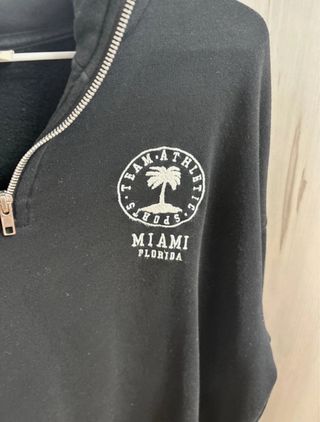 Sudadera negra con cremallera y logo