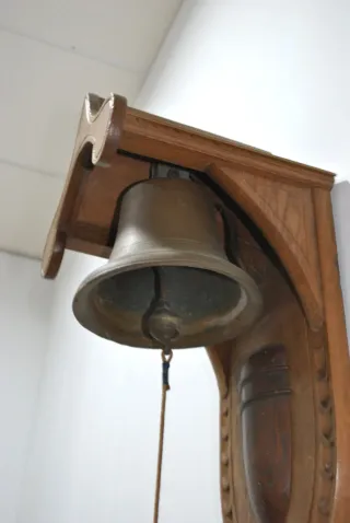 Antigua campana de pared con soporte de madera