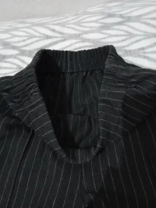 Pantalones gris oscuro de rayas. Con bolsillos.
