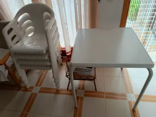 Mesa y 4 sillas de plástico blancas