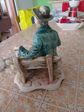 Statuina Capodimonte ceramica uomo su panchina
