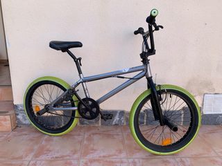 Bicicleta BMX gris con ruedas verdes