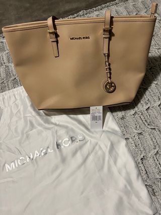 Bolso Michael Kors Rosa con detalles en dorado.