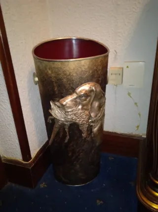 Paragüero de metal con perro y ave