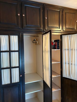 Armario de madera oscuro con puertas de cortinas
