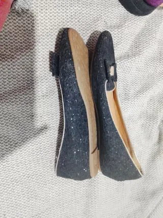 Zapatos negros brillantes con lazo dorado