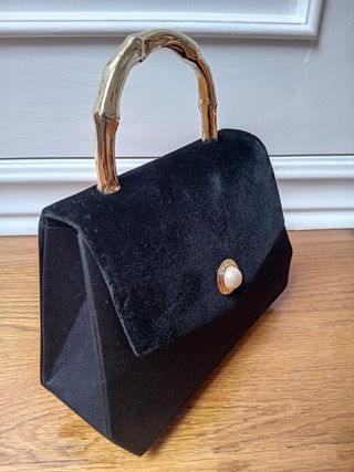 Bolso de mano negro con asa dorada