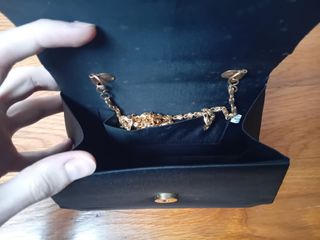 Bolso de mano negro con asa dorada